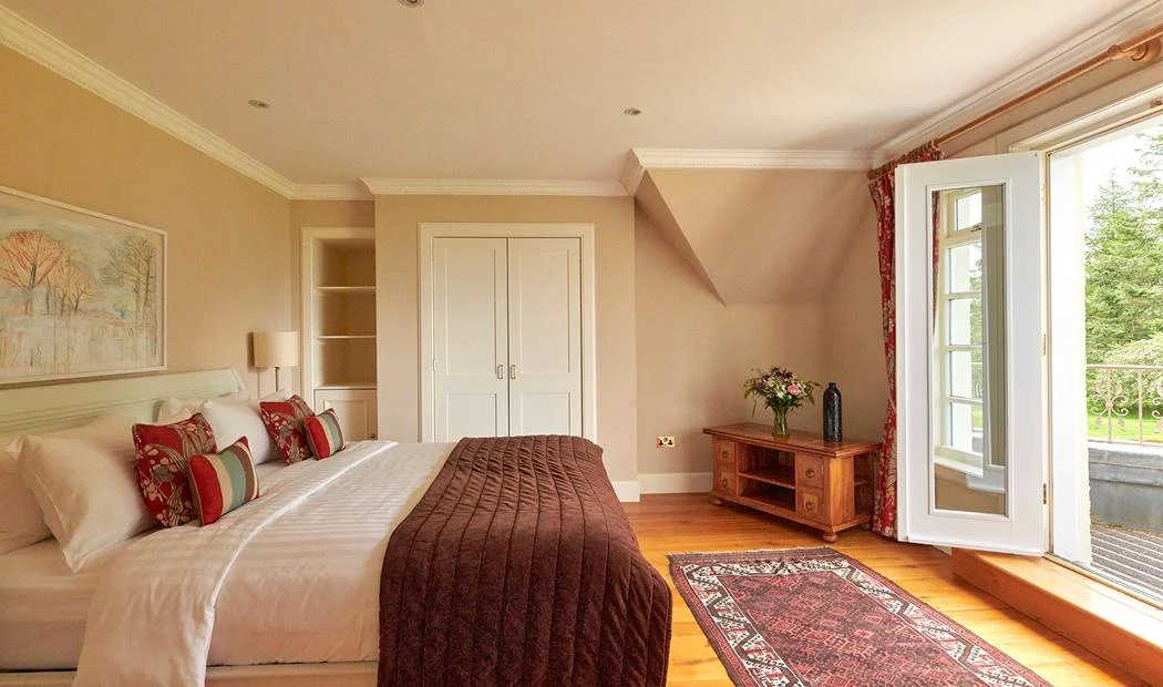 A warm Ardoch bedroom with a double bed and view over the garden
