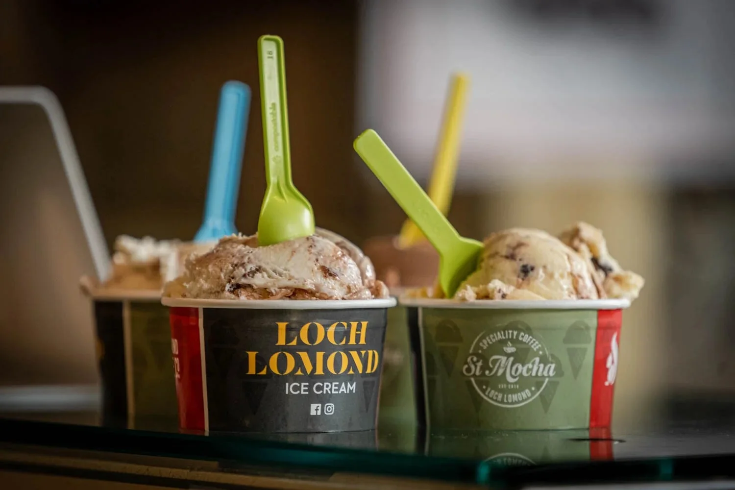 Cups of Loch Lomond ice cream with colourful spoons.